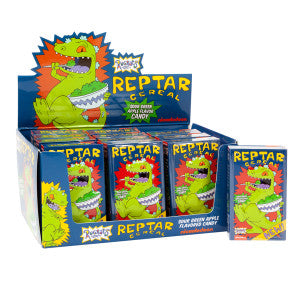 A display box containing multiple individual tins of Reptar Cereal candy with a green apple flavor, featuring the character Reptar from the Nickelodeon series Rugrats.