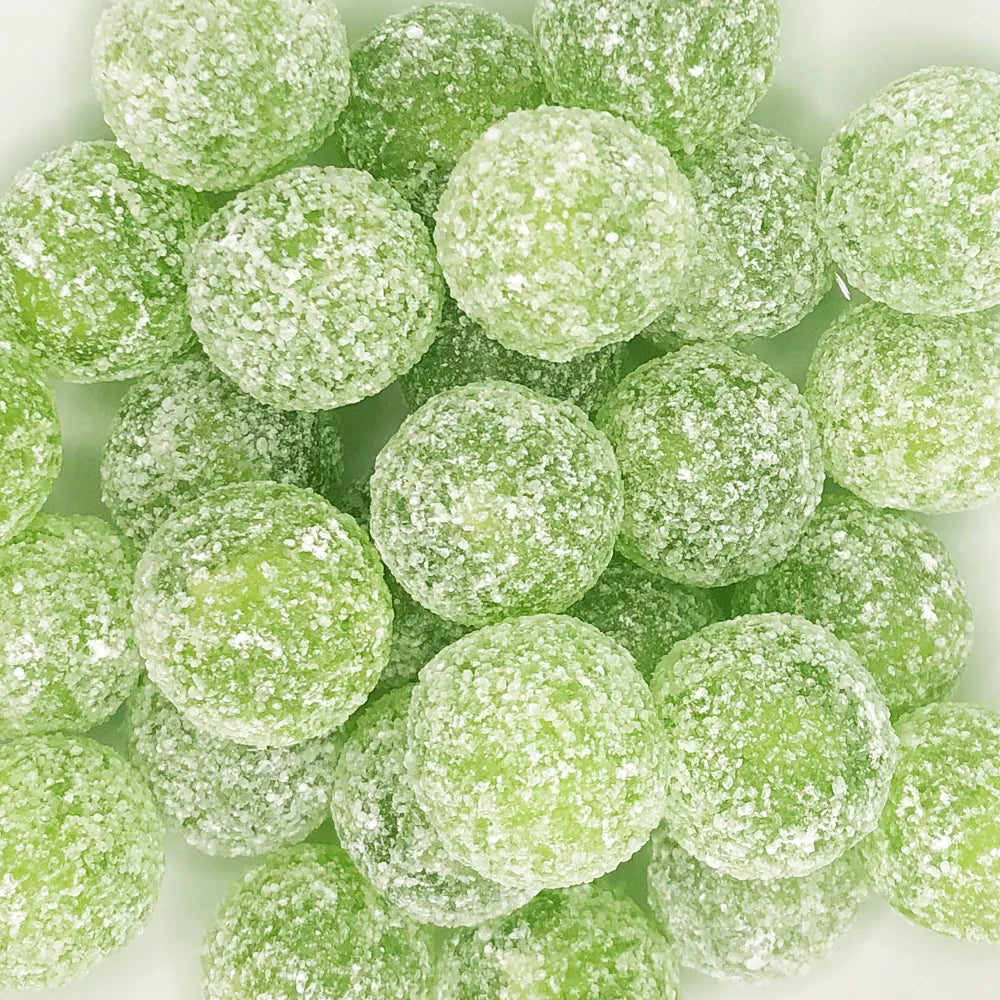 Close-up of green Barnetts Mega Sour Apple candy balls coated in an intense sour sugar layer.