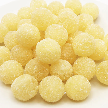 Close-up of sugar-coated Mega Sour Lemon candy balls with sour crystal coating