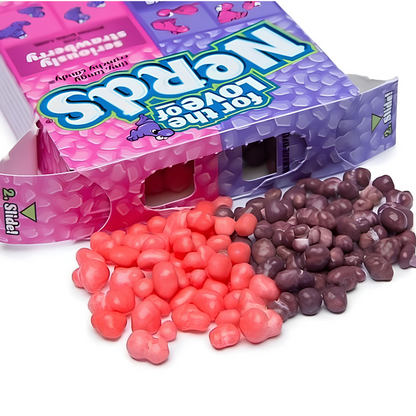 A box of Nerds candy with spilled pink strawberry and purple grape Nerds candies.